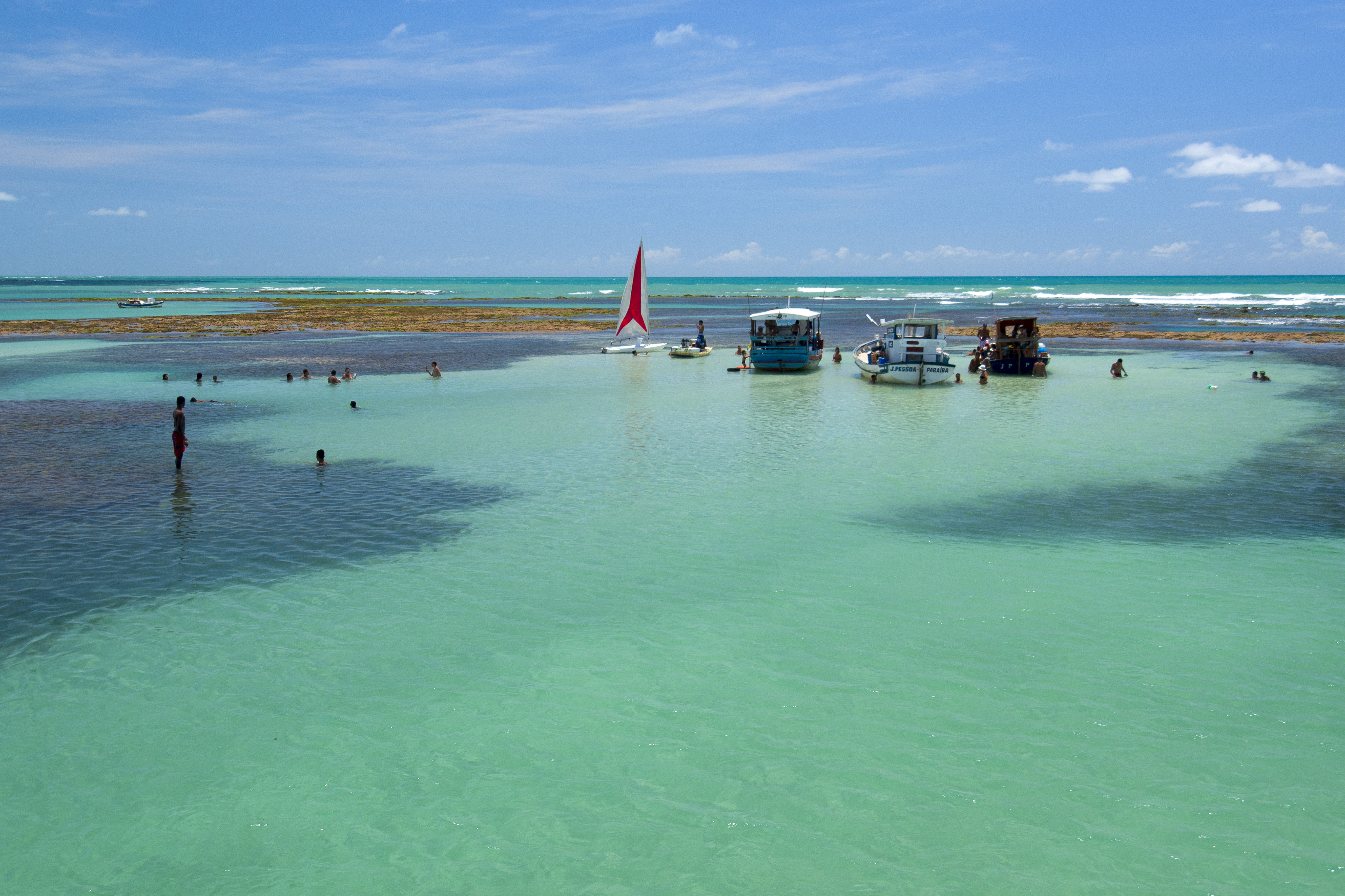 Águas das piscinas naturais do Seixas, com barcos ao fundo